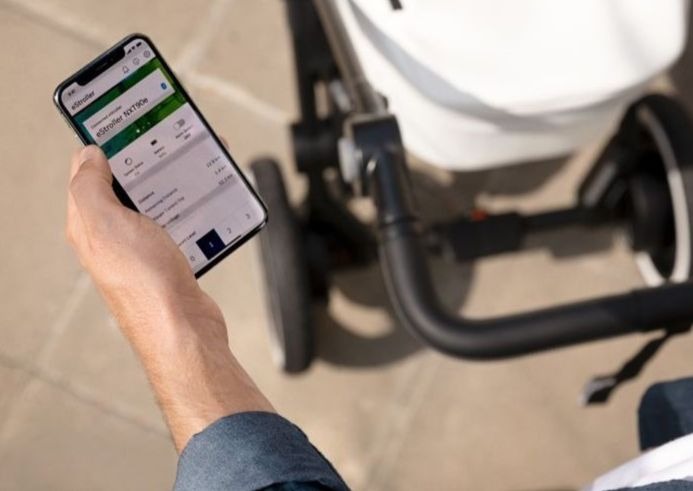 Un homme manipule son smartphone tout en conduisant une poussette